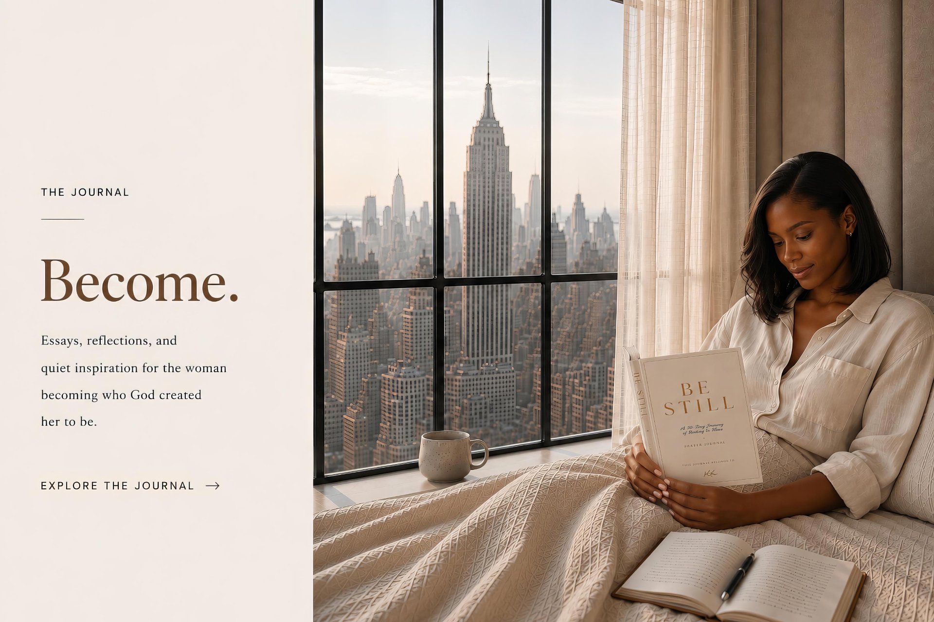 A woman reading the Be Still devotional journal in bed by a window overlooking the Manhattan skyline, with the Empire State Building framed in the window